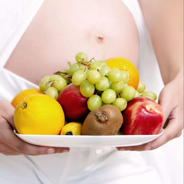 Pregnant woman holding fruits